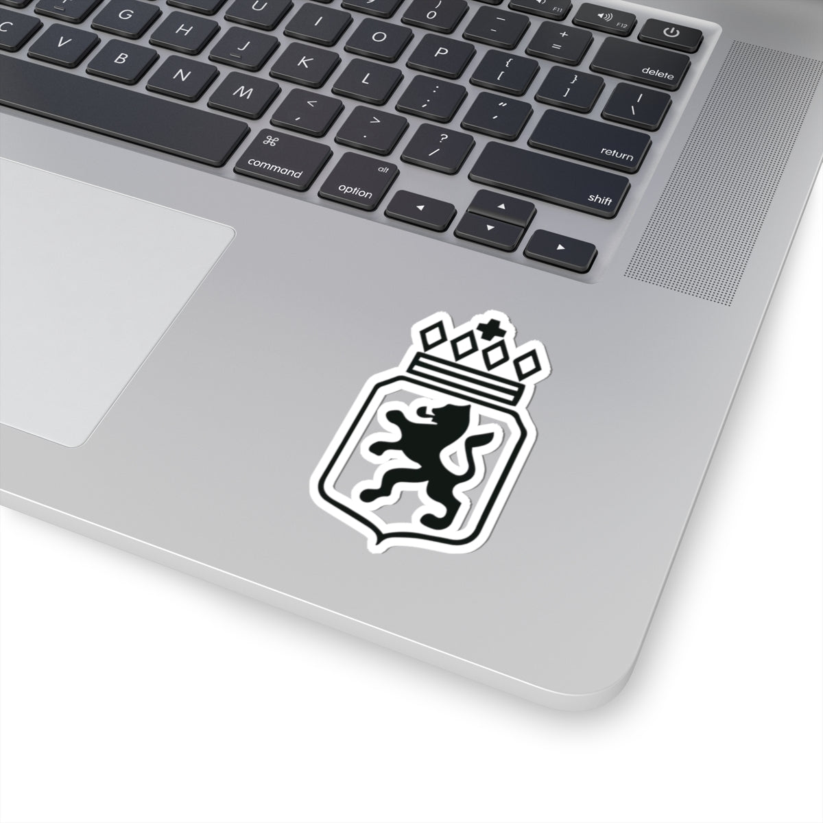 Laptop with a sticker of a lion and crown design on the palm rest area.