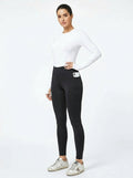 Women's black full-seat riding tights with silicone grip panel, white base layer and Golden Goose sneakers, front view