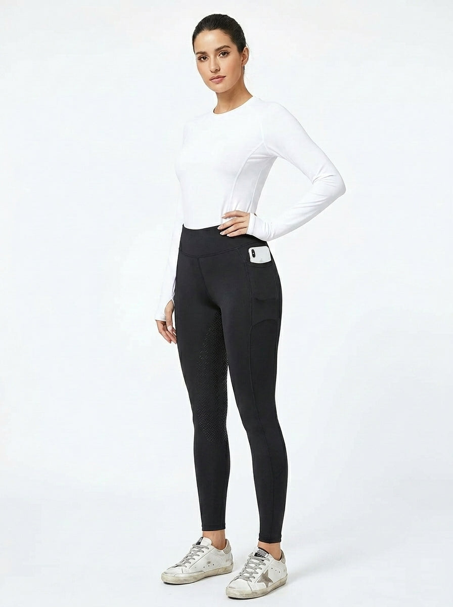 Women's black full-seat riding tights with silicone grip panel, white base layer and Golden Goose sneakers, front view