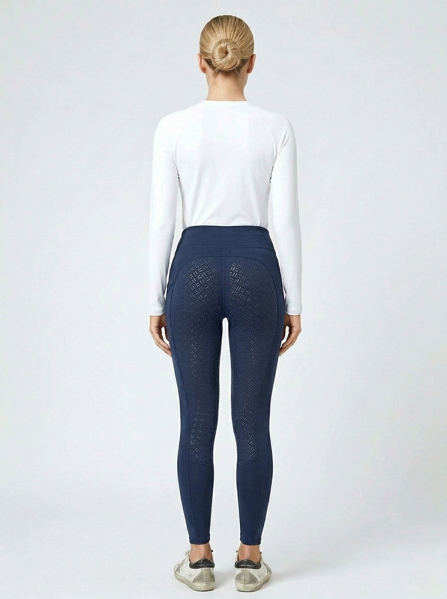 Women's navy blue full-seat riding tights showing full-seat silicone grip panel from behind, white base layer and Golden Goose sneakers