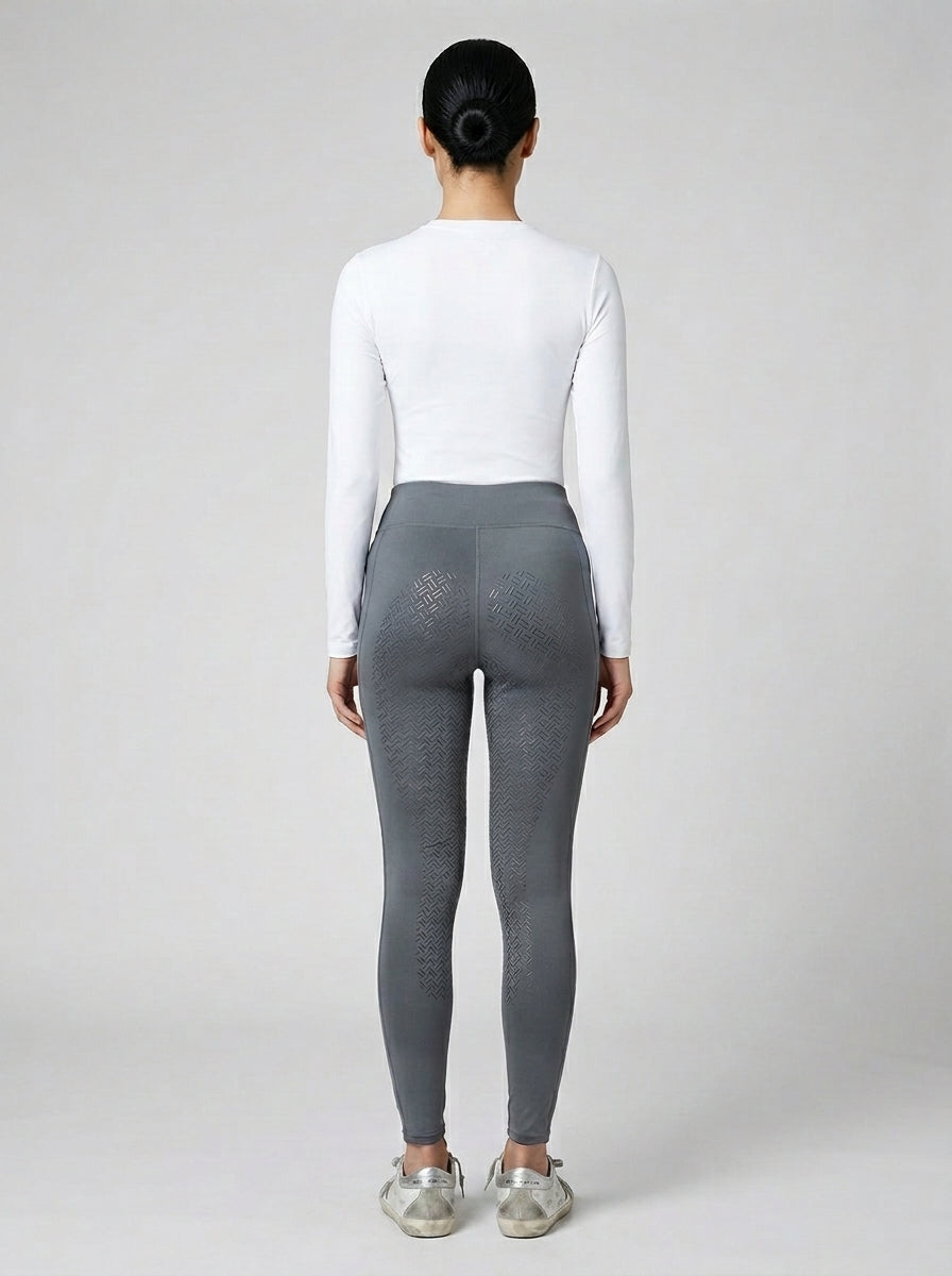 Women's grey full-seat riding tights showing full-seat silicone grip panel from behind, white base layer and Golden Goose sneakers